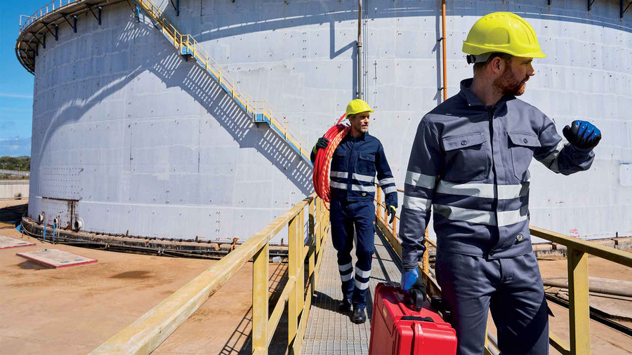 Two workers in Sir Safety Symbol workwear at an oil storage depot